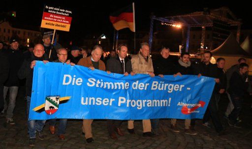 Alternative for Germany (AfD) politicians carry a banner written with \