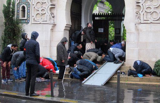 Believers kneeling at the Grand Mosque of Paris during Friday\