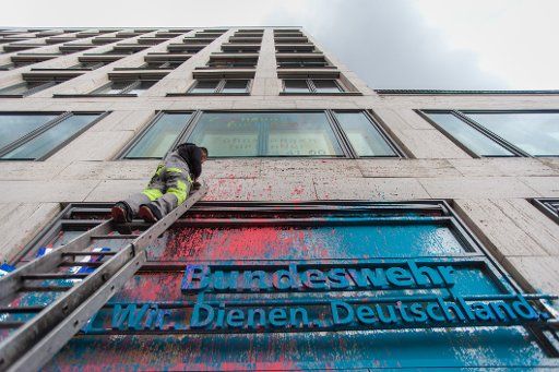 A worker cleans the front of a career counseling office of the German Army (Bundeswehr) after a paint bomb attack in Berlin, Germany, 09 Novemver 2015. Photo: Bastian Fischer\/