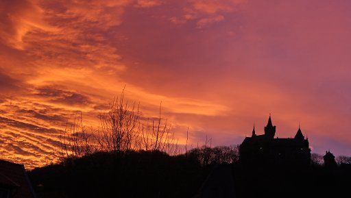 The Wernigerode Castle is silhouetted against a glowing morning sky in Wernigerode, Germany, 04 December 2015. Photo: Matthias Bein\/