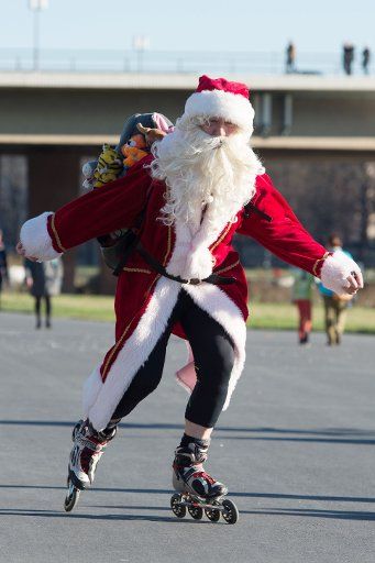A man dressed in a Santa Claus costume skates along the bike path on the banks of the Elbe River in Dresden, Germany, 06 December 2015. Photo: SEBASTIAN KAHNERT\/