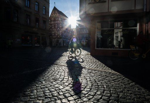 A cyclist casts a long shadow onto the pavement of a street during warm sunshine in Mainz, Germany, 26 December 2015. Photo: Frank Rumpenhorst\/