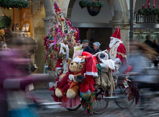 A man dressed as Santa Clause rides on his Christmas-decorated bicycle through the streets of Muenster, Germany, 10 December 2015. Photo: Friso Gentsch\/