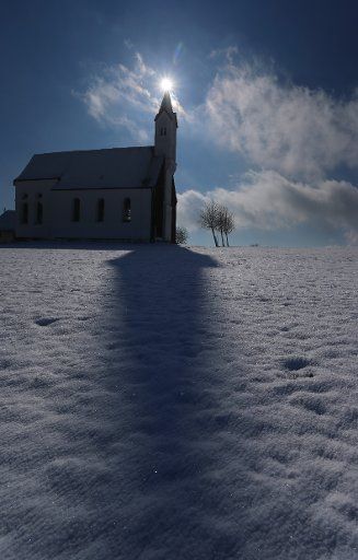 The tower of the Sankt Alban church casts a long shadow on freshly fallen snow, near Aitrang, Germany, 24 February 2016. PHOTO: KARL-JOSEF HILDENBRAND \/