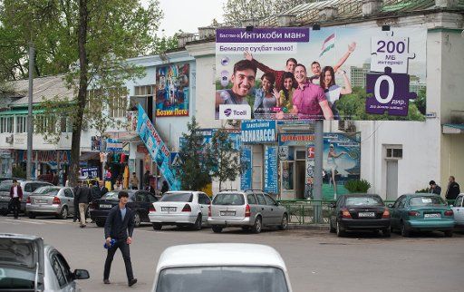 A man walks past a billboard for a cellular network in Dushanbe, Tajikistan, 01 April 2016. Photo: Bernd von Jutrczenka\/