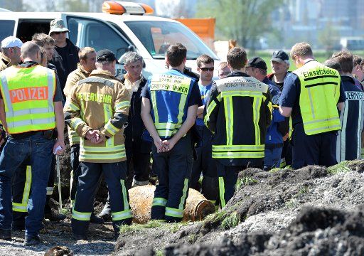 Rescue workers stand next to a defused aerial bomb near Derching, Germany, 21 April 2016. The around 500-kilogram bomb was discovered dring construction work. To defuse the bomb, the nearby A8 highway between Munich and Stuttgart needed to ...