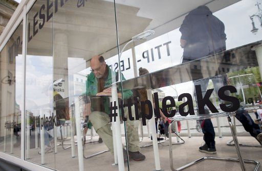 People read TTIP documents published by Greenpeace in a glass reading room at the Brandenburg Gate in Berlin, Germany, 03 May 2016. For years the USA and EU have been negotiating the TTIP trade agreements. The free trade agreement is highly ...