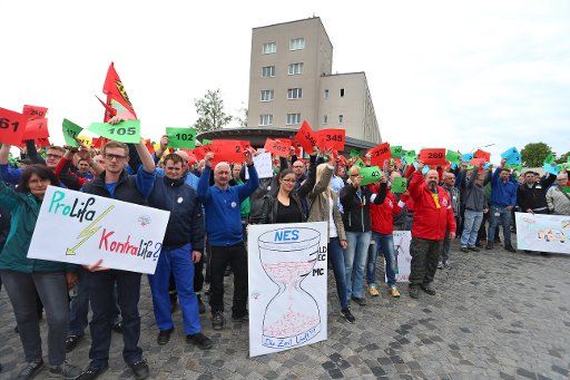 Siemens employees hold up numbered slips of paper in front of their plant in Bad Neustadt an der Saale, Germany, 18 May 2016. Every number represents a job that is currently at risk. The employees are protesting against the planned relocation of at ...