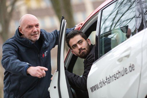 Driving instructor Dirk Konert of the German Red Cross (DRK) explaining the rules of traffic to 23-year-old Syrian refugee Fares Khalaf (l) in Bielefeld, Germany, 18 March 2016. PHOTO: OLIVER KRATO\/