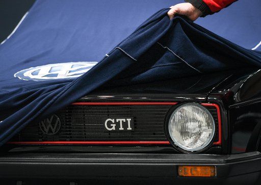 A Volkswagen employee covers a Golf GTI at the VW booth at the Hanover Fair in Hanover, Germany, 24 April 2016. The world\
