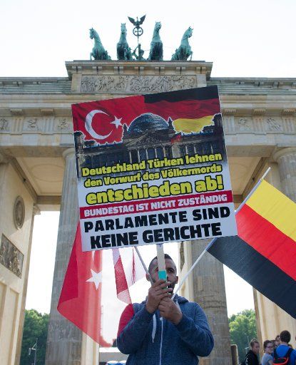 A protester posing at the Brandenburg Gate in Berlin, Germany, 01 June 2016. According to police, around 1000 Turkish attendees demonstrated against the lanned Bundestag resolution on the Armenian genocide. Photo: Paul Zinken\/