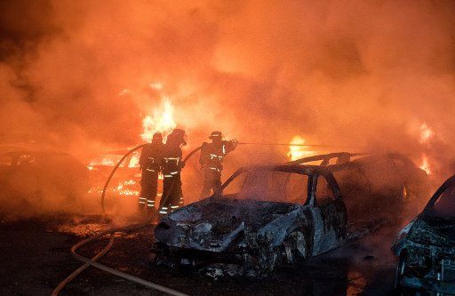 Firefighters extinguish burning cars in Hamburg, Germany, 02 June 2016. 14 vehicles, including several stretch limousines, caught fire at the site of an car rental in the district of Lohbruegge early Thursday morning. Photo: DANIEL BOCKWOLDT\/