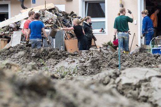 Residents and helpers clear mud and debris in Simbach am Inn, Germany, 04 June 2016. Clean-up operations in the flood-affected areas in the Lower Bavarian region are underway. Photo: ARMIN WEIGEL\/