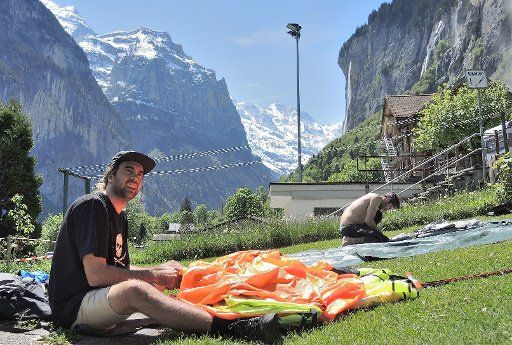 Bob from Australia packing up his parachute in Lauterbrunnen, Switzerland, 26 May 2016. Every year, hundreds of basejumpers travel to the cliffs of Lauterbrunnen. PHOTO: THOMAS BURMEISTER\/