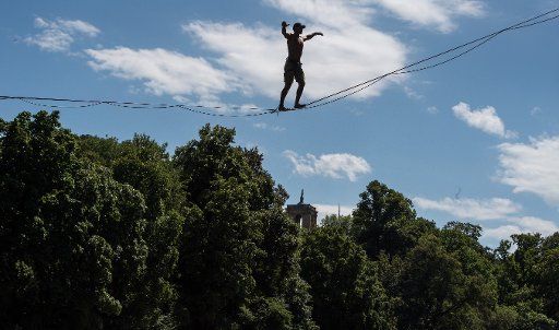 Slacliner Steve Pucker balancing on a 75 meter long rope above the Isar river in Munich, Germany, 4 August 2016. PHOTO: PETER KNEFFEL\/
