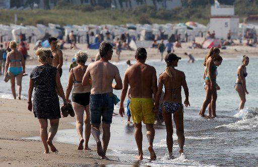 Holidaymakers walking along the beach in hot weather at the Baltic Sea in Warnemuende, Germany, 13 September 2016. PHOTO: BERND WUESTNECK\/
