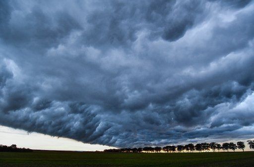 Dark clouds move over a field near Sieversdorf, Germany, 04 September 2016. Photo: PATRICK PLEUL\/