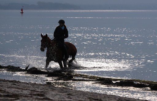 A woman riding along the Baltic Sea beach on the island Poel near Timmendorf, Germany, 6 November 2016. PHOTO: JENS BUETTNER\/