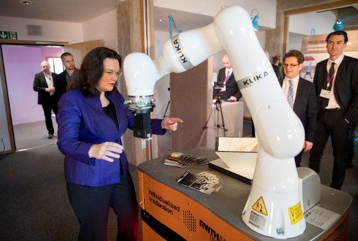 German Employment Minister Andrea Nahles (SPD) pictured beside a robot arm manufactured by Kuka, at an exhibition on workplace 4.0 at in Berlin, Germany, 29 November 2016. The minister is to present her white paper Arbeiten 4.0 (lit. Working 4.0) ...