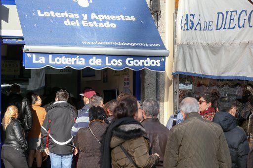 Locals stand in line outside a shop selling lottery tickets in Madrid, Spain, 08 December 2016. Photo: Friso Gentsch\/