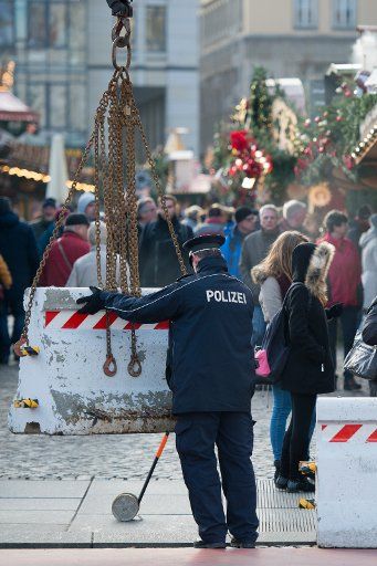 A police officer positions concrete blocks at an entrance to the Striezelmarkt Christmas market in Dresden, Germany, 20 December 2016. In the wake of events in Berlin, Dresden police are adapting the security measures for the Striezelmarkt in ...