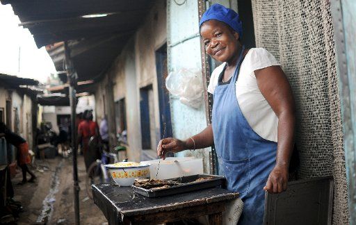 A woman cooks for her small restaurant in the compound Chawama of Lusaka, Zambia, 9 March 2016. Photo: Britta Pedersen\/dpa-Zentralbild\/