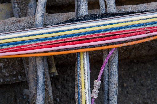 Colourful telecommunications cables made out of fibreglass in a construction trench in Munich, Germany, 27 March 2017. Photo: Peter Kneffel\/