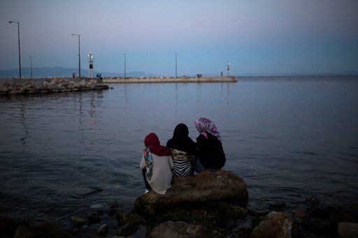 Migrants sitting on the beach at the Souda refugee camp on the island of Chios, Greece, 26 April 2017. Some 3700 refugees and migrants are located on the Aegean island of Chios. Photo: Angelos Tzortzinis\/