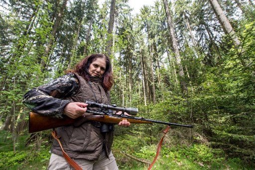 ILLUSTRATION - Hunter Karolina Hirsch standing with a gun in the forest near Vohenstrauss, Germany, 9 May 2017. Bavaria\