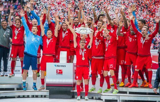 ARCHIVE - Philipp Lahm and the Bayern Munich squad celebrate winning their 25th Bundesliga championship trophy after beating FSV Mainz in Munich, Germany, 23 May 2015. Photo: Marc Müller\/