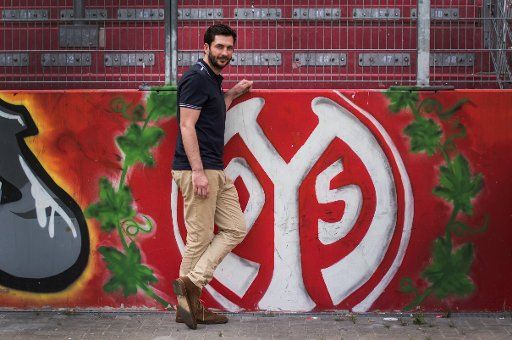 The new coach of German Bundesliga soccer club Mainz 05, Sandro Schwarz, poses in front of the club logo after a press conference in Mainz, Germany, 31 May 2017. Photo: Andreas Arnold\/