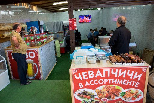 Passersby and guests watch the opening game between Russia and New Zealand on a TV in a snack shop in Sochi, Russia, 17 June 2017. Photo: Christian Charisius\/