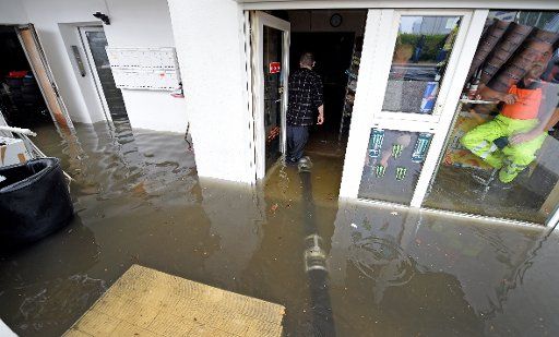 Fire fighters work on freeing a garage that has been flooded during heavy rainfall in Langenhagen-Schulenburg, Germany, 29 June 2017. Photo: Holger Hollemann\/