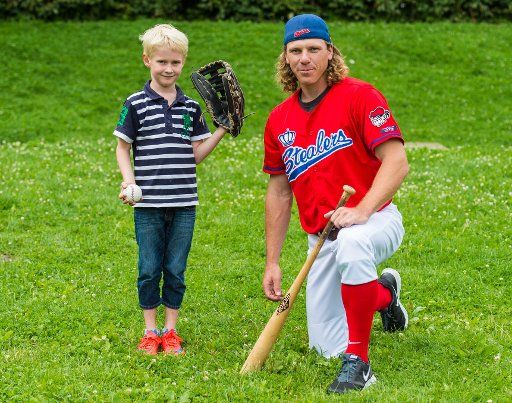 The internationally renowned baseball player from Hamburg, Michael "Mitch" Franke (R), kneeling holding a bat next to Jan-Hendrik (7), who is wearing a baseball mitt, in Hamburg, Germany, 24 July 2017. The former professional baseball player offers ...