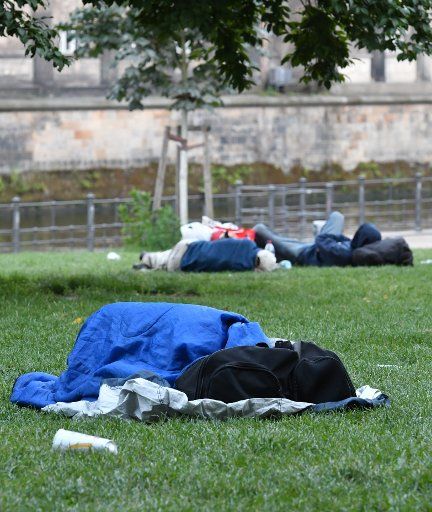 Three men lying on the grass and sleeping at the James Simon Park in Berlin, Germany, in the morning of 02 Augustr 2017. Photo: Paul Zinken\/