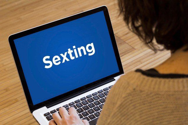 women using sexting on a laptop screen. Screen graphics are made up.
