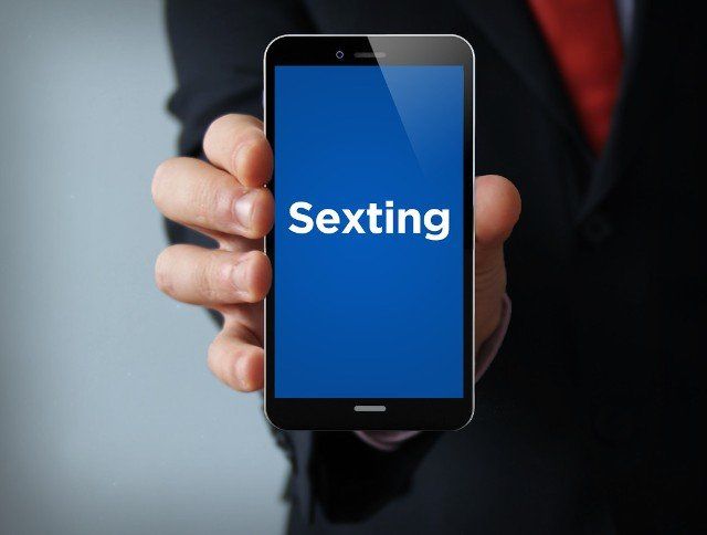 businessman holding a 3d generated touch phone with sexting app on the screen. Screen graphics are made up