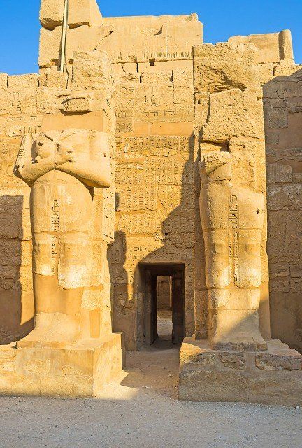 The tiny jib-door between the ruins of the large mummy statues in the Temple of Ramesses III in Karnak Complex, Luxor, Egypt.