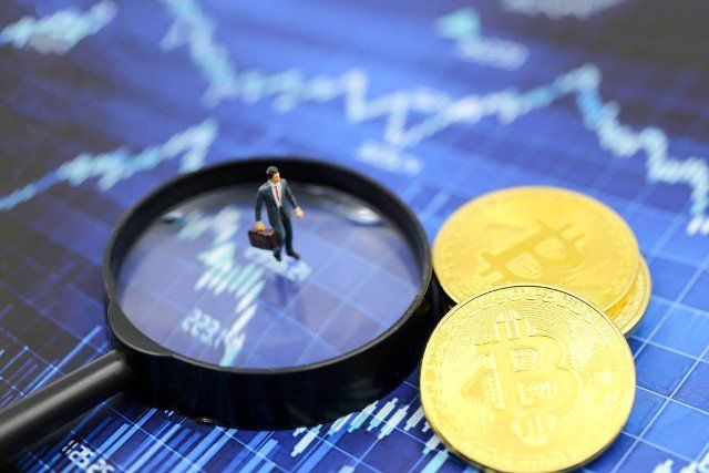 Miniature people : Businessman with Magnifying glass of bitcoin graph chart ,bitcoin Stock Market Analysis