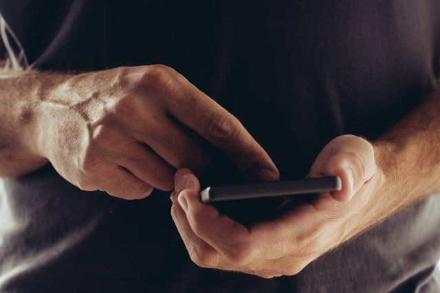 Sexting on mobile phone, man using smartphone app to send sexy texts and messages