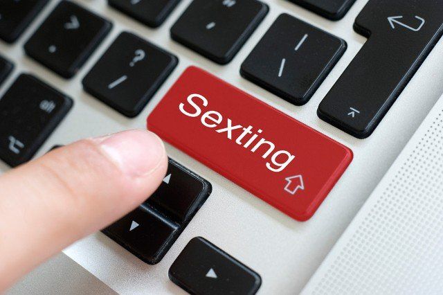 Someone is about to push the button of sexting on the keypad of a laptop