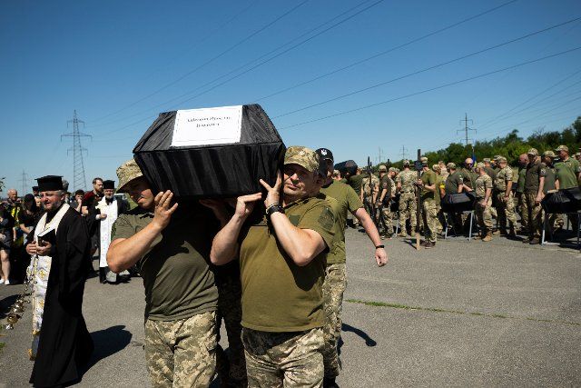 Soldiers carry the bodies of the 13 soldiers who fell on the battlefront, who were buried in the Krasnopilske cemetery, in Dnipro, Ukraine, 01 July 2022. EFE\/ Orlando Barria