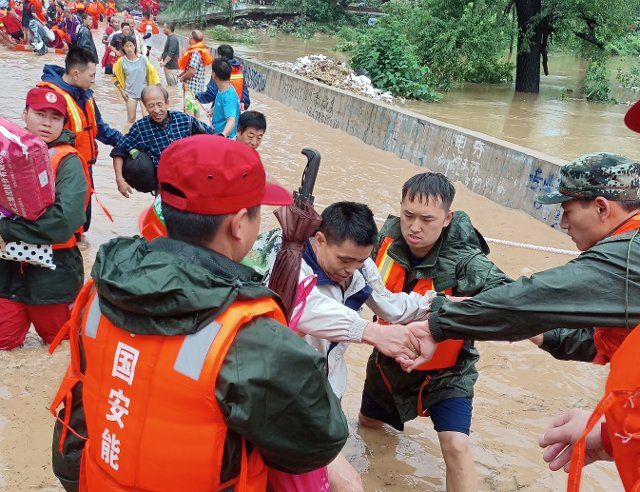 Rescuers evacuate villagers trapped by the flood in Xinxiang in central China\