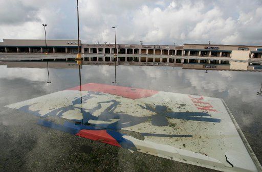 KRT US NEWS STORY SLUGGED: WEA-RITA KRT PHOTOGRAPH BY RALPH LAUER\/FORT WORTH STAR-TELEGRAM (DALLAS OUT) (September 28) GROVES, TX -- A Kentucky Fried Chicken sign lsits under standing water in the parking lot of the Jefferson City mall in Groves,...