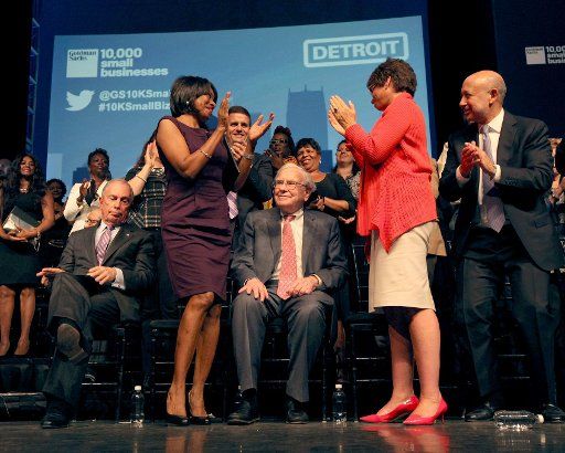 Carla Walker-Miller, CEO of Walker-Miller Energy Services, standing left, and Valerie Jarrett, White House senior advisor, clap on either side of Warren Buffett as he receives a standing ovation during the Goldman Sachs celebration ceremony of the first graduating class of the 10,000 Small Businesses in Detroit at Wayne State University in September 2014. (Jessica J. Trevino\/Detroit Free Press\/TNS)