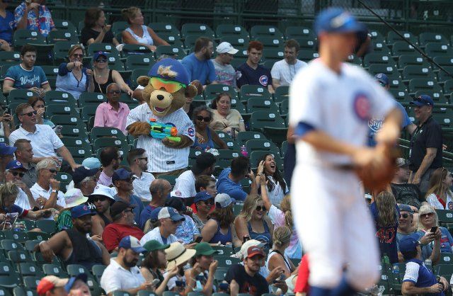 Clark the Cub uses a squirt gun on fans in the seventh inning of a Chicago Cubs-Colorado Rockies game at Wrigley Field on August 25, 2021 in Chicago. (John J. Kim\/Chicago Tribune\/TNS
