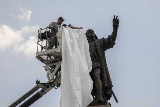 A statue of Christopher Columbus is covered before faith leaders and politicians participate in the Juneteenth faith-led peaceful demonstration on Columbus Drive in Grant Park on June 19, 2020, in Chicago. (Zbigniew Bzdak\/Chicago Tribune\/TNS