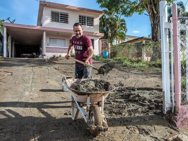 Samuel Santiago removes mud from the front of his house in the SanJose de Toa Baja neighborhood that was flooded due to over flow of the river Rio de la Plata as Hurricane Fiona passed by Puerto Rico on Monday Sept. 18, on Wednesday, Sept. 20, 2022. (Pedro Portal\/Miami Herald\/TNS