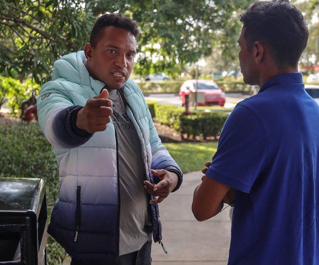 A recent Venezuelan migrant, left, who had been chosen by the recruiters as a sort of team captain of a work crew that helped with Hurricane Ian recovery, expresses anger toward Pedro Escalona, 24, for speaking to journalists on Oct. 10, 2022. (Carl Juste\/Miami Herald\/TNS