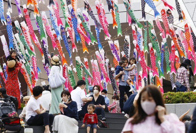 People wearing masks to protect against the novel coronavirus gather around carp streamers decorated at Tokyo Tower on May 4, 2021, during the Golden Week holiday period in Japan. (Kyodo) ==Kyodo